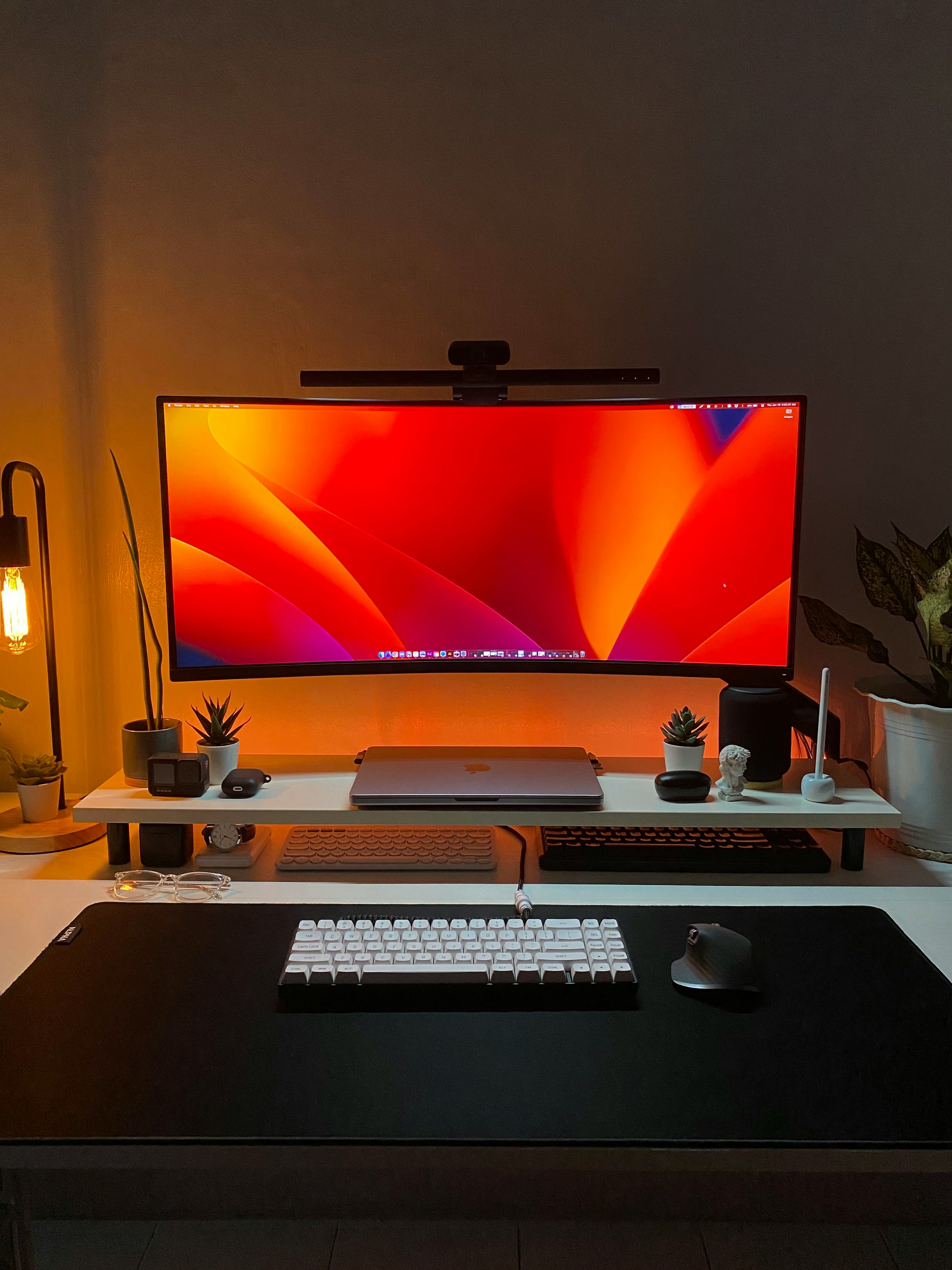 Curved monitor displaying colorful wallpaper on a modern creative desk setup
