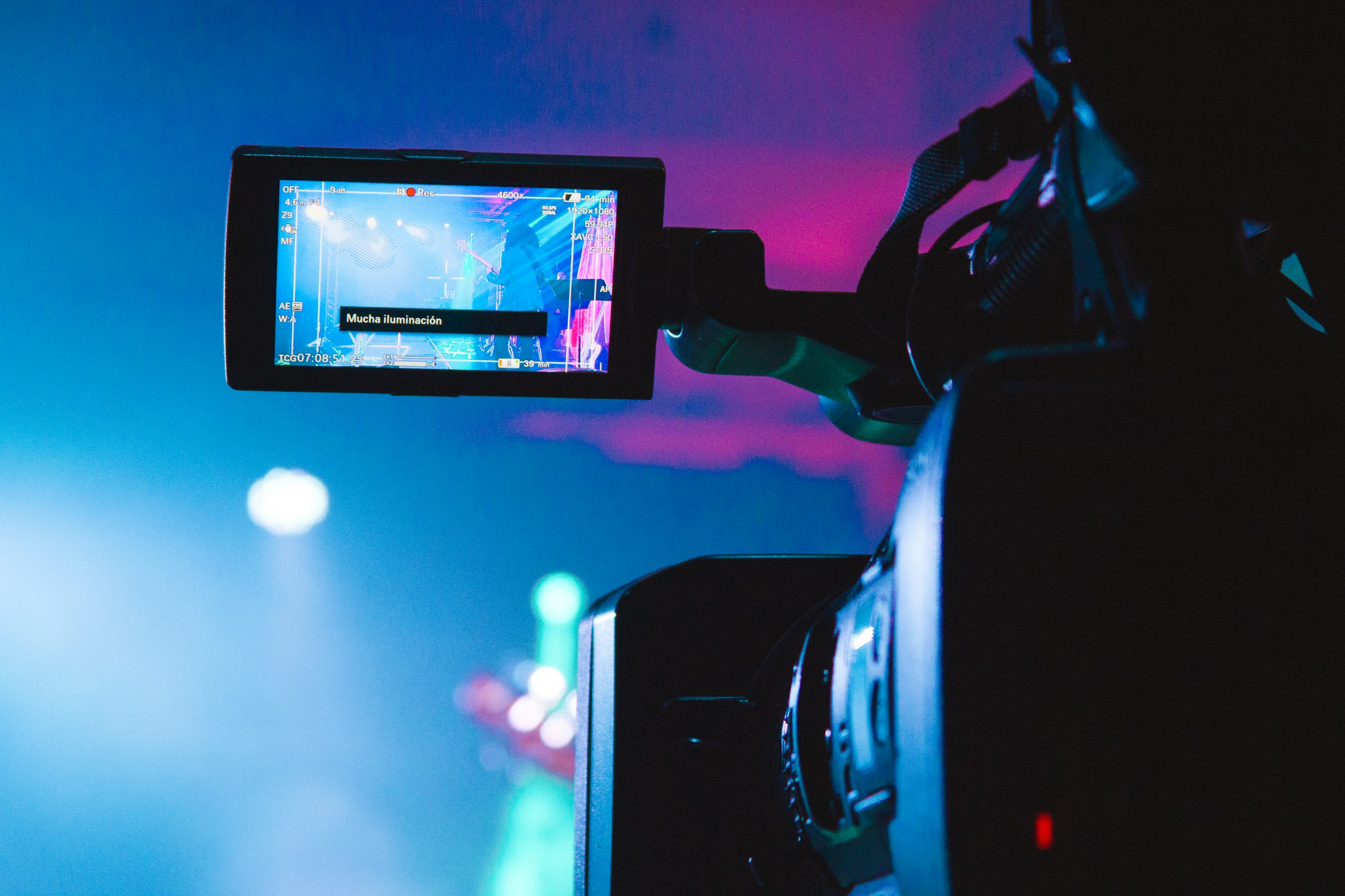 Video camera filming a stage in colorful light