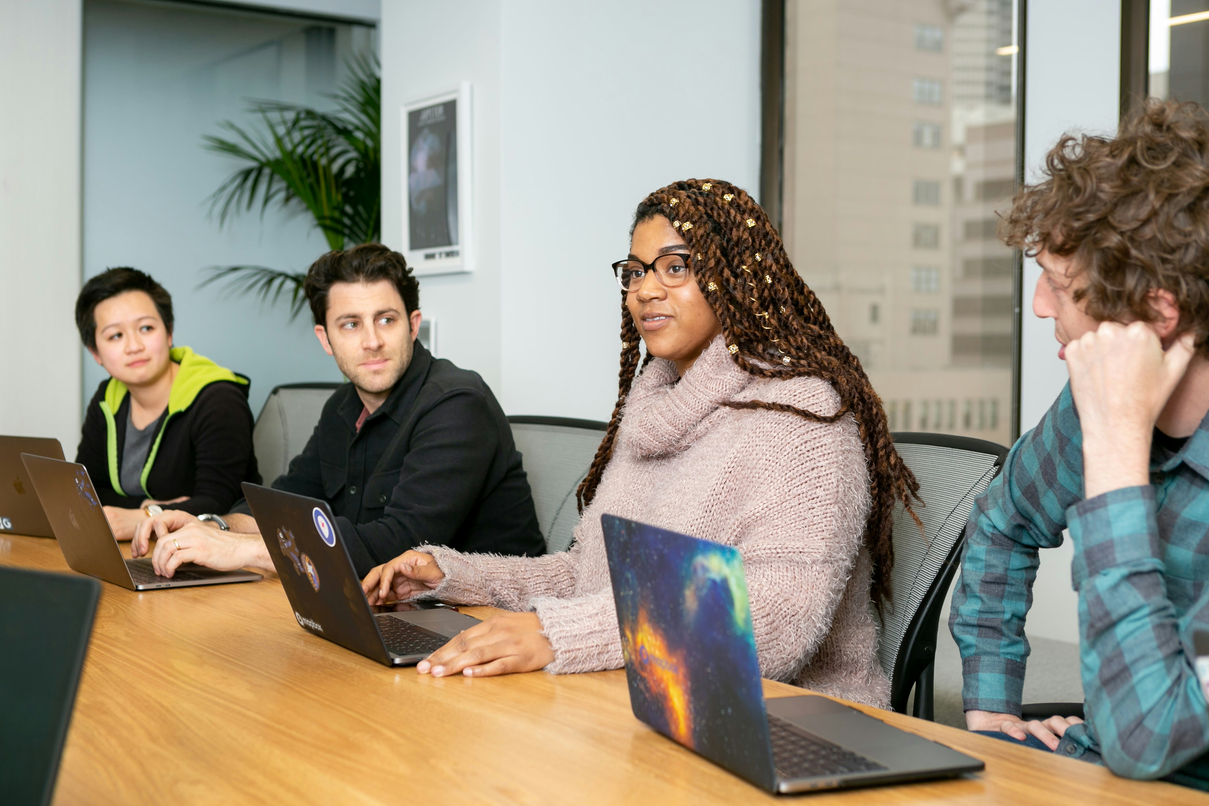 Team collaborating on laptops in a modern office meeting room